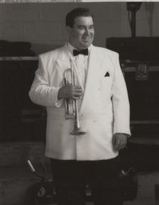 Vince Pettinelli with trumpet in white dinner jacket